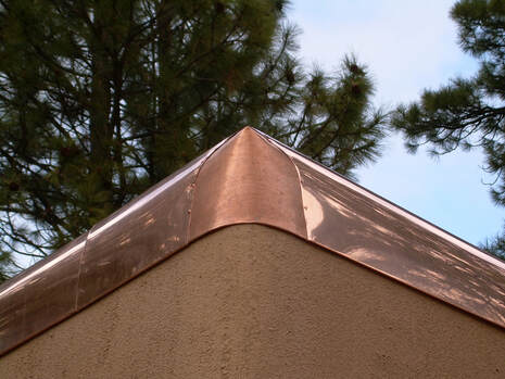 Photo of copper cap flashing on corner exterior of roofline.